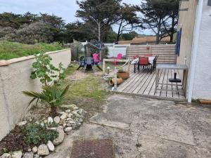 Les Sables VignierにあるAppartement les pieds dans l eauのパティオ(デッキの椅子とテーブル付)