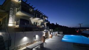 a house with a swimming pool at night at Villa Serafeim in Kymi