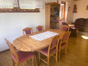 ein Holztisch mit Stühlen drumherum in einem Wohnzimmer in der Unterkunft Der Fjordtraum in Balestrand direkt am Wasser in Balestrand + 23 Fotos