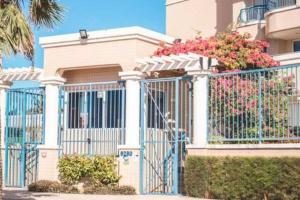 a house with a blue gate with flowers on it at Apartamento aconchegante de frente para a praia in Fortaleza