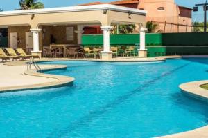 a large swimming pool with a gazebo at Apartamento aconchegante de frente para a praia in Fortaleza