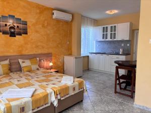 1 dormitorio con 1 cama grande y cocina en Guest House Nikolovi, en Lozenets