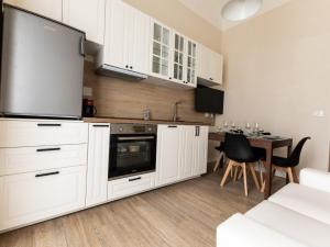 a kitchen with white cabinets and a table with chairs at La casa di Gazi in Florence