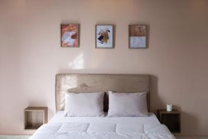 1 dormitorio con 1 cama con 4 cuadros en la pared en Alex Inn en Alexandria
