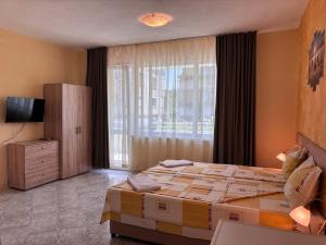 Un dormitorio con una cama grande y una ventana en Guest House Nikolovi, en Lozenets