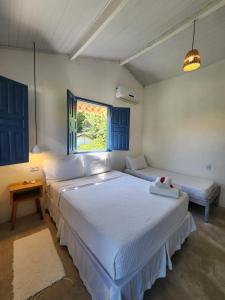 1 dormitorio con 2 camas y ventana en Pousada Sol Nascente Caraíva, en Caraíva
