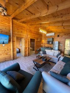 a living room with wooden walls and furniture in a cabin at اكواخ السمو الريفيه in Khalij Salman