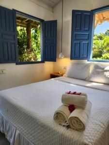 a bedroom with a bed with two towels on it at Pousada Sol Nascente Caraíva in Caraíva