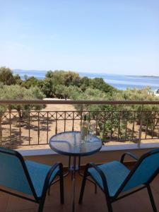 a table and chairs on a balcony with the ocean at ML Aretes in Toroni