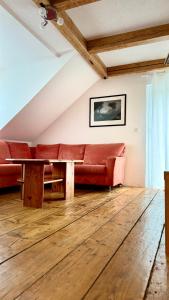 a living room with a red couch and a table at Sonnenblick Ferienwohnung in Wirsberg