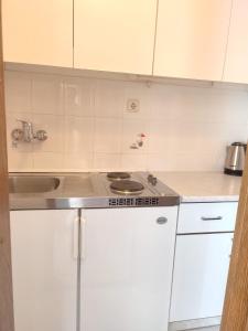 a small kitchen with a stove and a sink at Apartments Glavinović - Near Beach and Center, Free Parking in Povlja