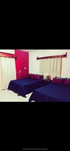 a bedroom with two beds and a red wall at Casa La Prieta Linda in Tamasopo