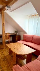a living room with a red couch and a wooden table at Sonnenblick Ferienwohnung in Wirsberg