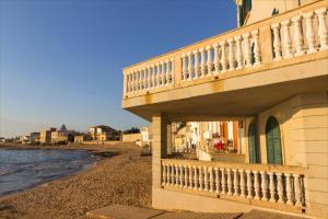 een gebouw met een balkon naast het strand bij La terrazza della Dolce Casa - Blue Wave - Casuzze in Villaggio Azzurro