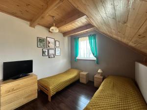 a small room with two beds and a television at Agrogajówka in Gniewino