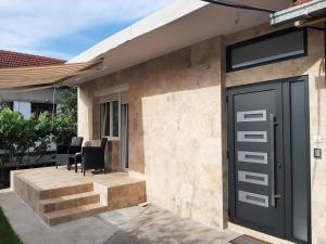 a house with a black door and black chairs at Nikolic Apartment 2 in Leskovac