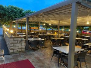 una zona de comedor al aire libre con mesas y sillas por la noche en LIGHTPLACE • Größere Gruppen • 4 Einzelzimmer • Boxspring • Smart TV • Biergarten • Restaurant, en Brunswick