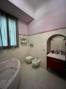 y baño con bañera, lavamanos, aseo y bañera. en Antinori apartment, en Florencia