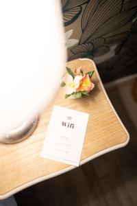eine Karte auf dem Tisch mit einer Blume darauf. in der Unterkunft Villa Vichéia - Appartement 31 in Vichy