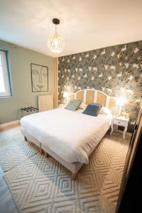 ein Schlafzimmer mit einem großen Bett in einem Zimmer in der Unterkunft Villa Vichéia - Appartement 31 in Vichy