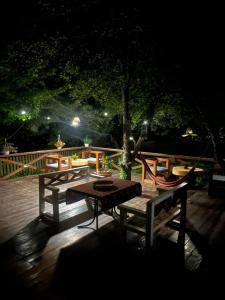 una mesa y bancos en una cubierta por la noche en Ioska's House en Mestia