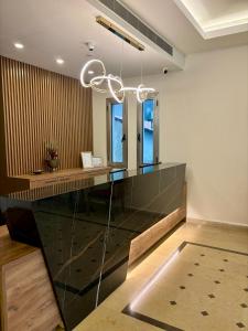 um átrio com um balcão de vidro e um lustre em Byblostar Hotel em Jbeil