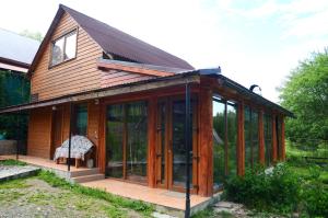 a house with glass doors on the side of it at Gostynnyi Dvir u Marichky in Lazeshchyna