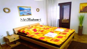 - une chambre dotée d'un lit avec une couverture jaune et rouge dans l'établissement House White Stone Split, à Podstrana