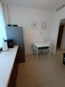 a kitchen with a table and a table and a refrigerator at Apartament Southy in Koszalin +2 photos