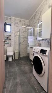 a bathroom with a shower and a washing machine at Lux Apartment Nea Kallikratia in Nea Kalikratia