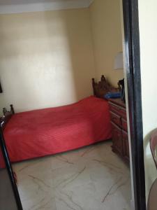 a bedroom with a red bed and a wooden dresser at Maison avec piscine pour famille au région de safi in Safi