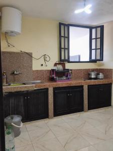 a kitchen with black cabinets and a window at Maison avec piscine pour famille au région de safi in Safi