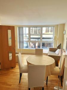 ein Wohnzimmer mit einem Tisch, Stühlen und einem Sofa in der Unterkunft Convenient 2 BDR 2BA Flat in Central London in London