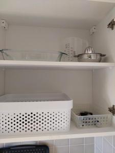 a kitchen with white shelves with bowls and utensils at Ferienwohnung Am Bürgerteich 2 in Bischofswerda +56 photos