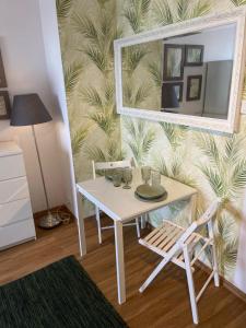 a table with two chairs and a mirror on a wall at Apartament Modlińska in Warsaw