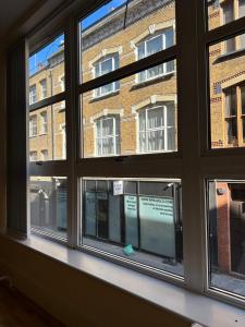 ein Fenster mit Blick auf ein Backsteingebäude in der Unterkunft Convenient 2 BDR 2BA Flat in Central London in London