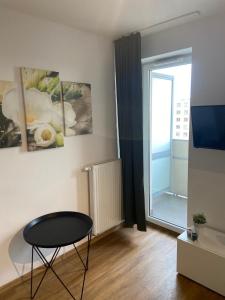 a living room with a table and a window at Apartament Modlińska in Warsaw