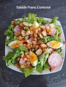 um prato de salada com camarão e vegetais numa mesa em Séjour chaleureux chambre chez l habitant em Torpes