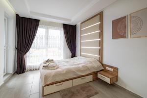 a bedroom with a bed and a window at Boutique 1 bedroom apartment with Private Parking and Port View in Varna City