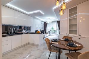 a kitchen and dining room with a table and chairs at Boutique 1 bedroom apartment with Private Parking and Port View in Varna City