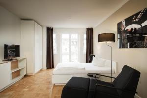 una camera d'albergo con letto e sedia di SMARTments business Hamburg Aussenalster ad Amburgo