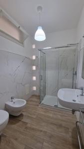 Un baño con dos lavabos y una ducha de cristal. en Appartamenti Palinuro Isca, en Palinuro