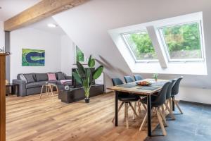 a living room with a table and chairs and a couch at Heilsteinlodge in Einruhr