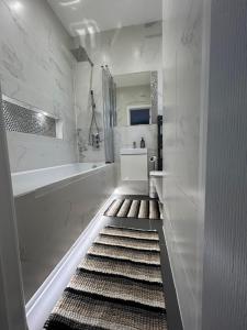 łazienka z wanną i dywanem w obiekcie Dana’s bungalow w mieście Horley