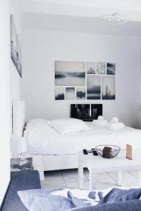 een witte slaapkamer met een wit bed en een tafel bij Gk Suites-Constantin view , auto check-in 24h in Larisa
