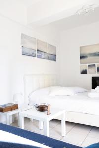 een witte slaapkamer met een bed en 2 tafels bij Gk Suites-Constantin view , auto check-in 24h in Larisa