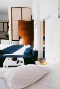 een slaapkamer met een bed en een blauwe bank bij Gk Suites-Constantin view , auto check-in 24h in Larisa
