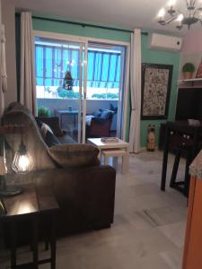 - un salon avec un canapé et une fenêtre dans l'établissement Sela Playa, à Roquetas de Mar