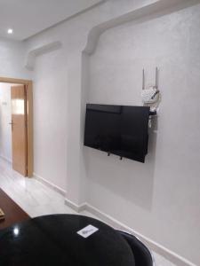 ein Wohnzimmer mit einem Flachbild-TV an der Wand in der Unterkunft Hassan in Rabat