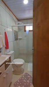 uma casa de banho com um chuveiro, um WC e um lavatório. em Pousada Recanto da Paz em Urupema